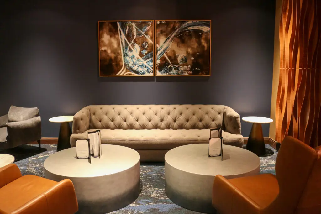 Lounge area with tufted sofa and artwork.