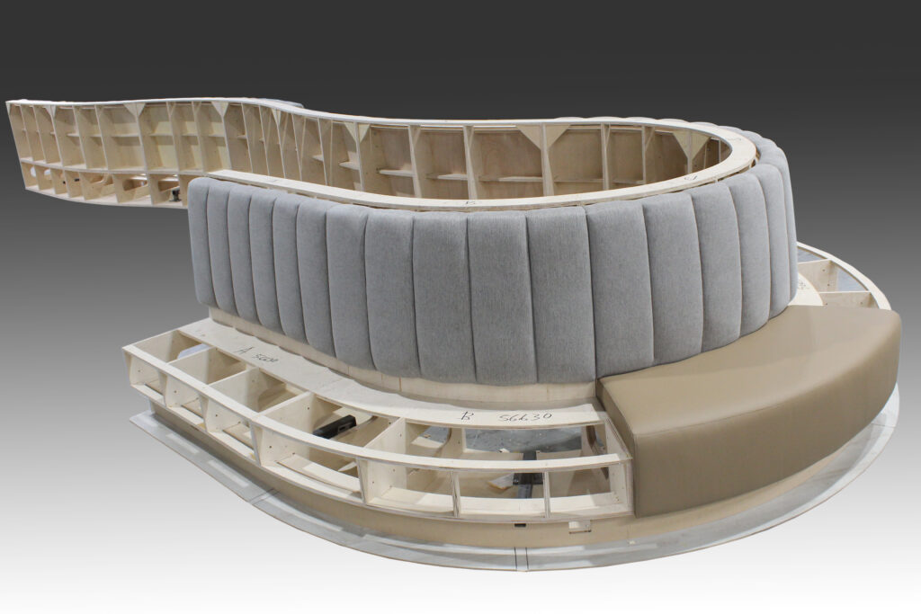 Curved upholstered seating structure under construction.